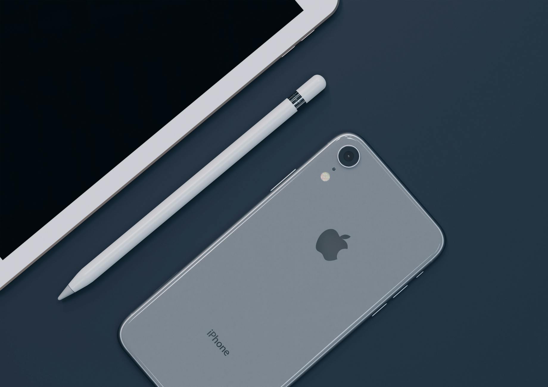 Sleek design of Apple iPhone, iPad, and Pencil highlighting modern technology.