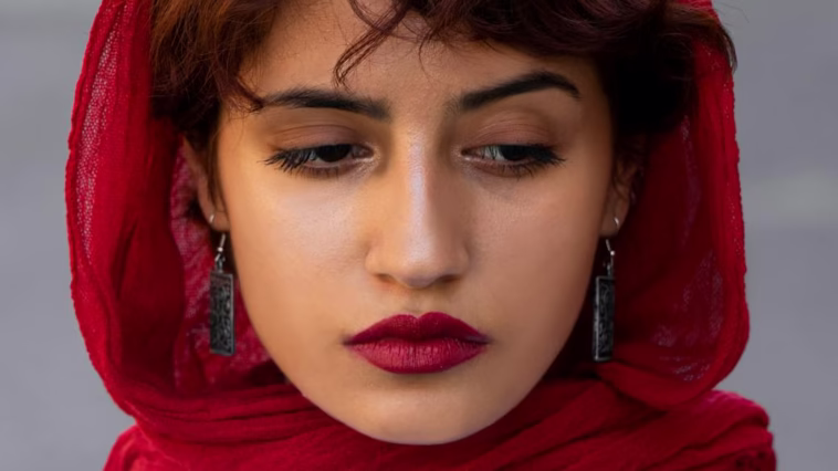 A portrait of a woman in a red scarf, exuding a moody and dramatic ambiance.